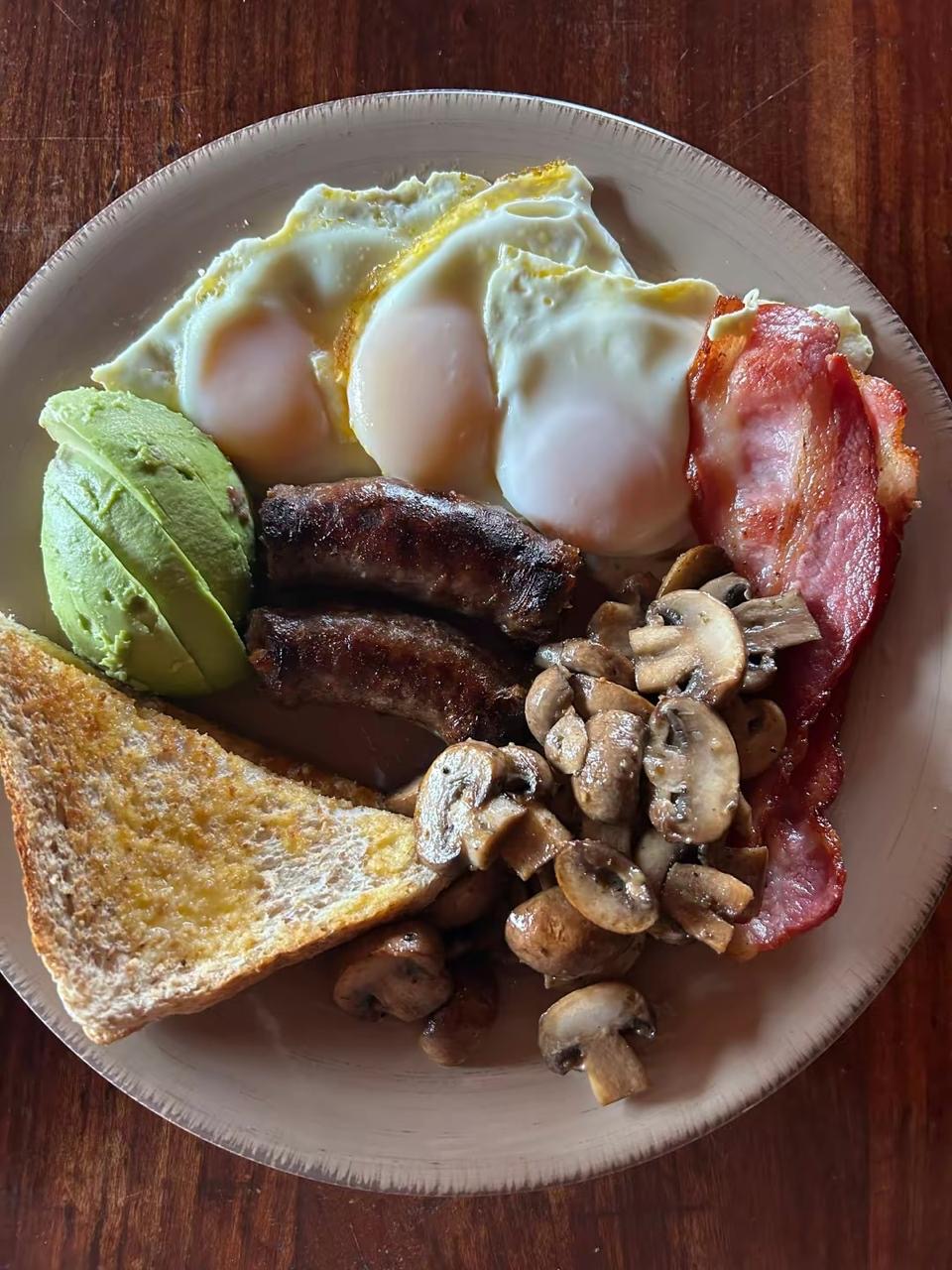 Breakfast with eggs, avocado, toast and mushrooms