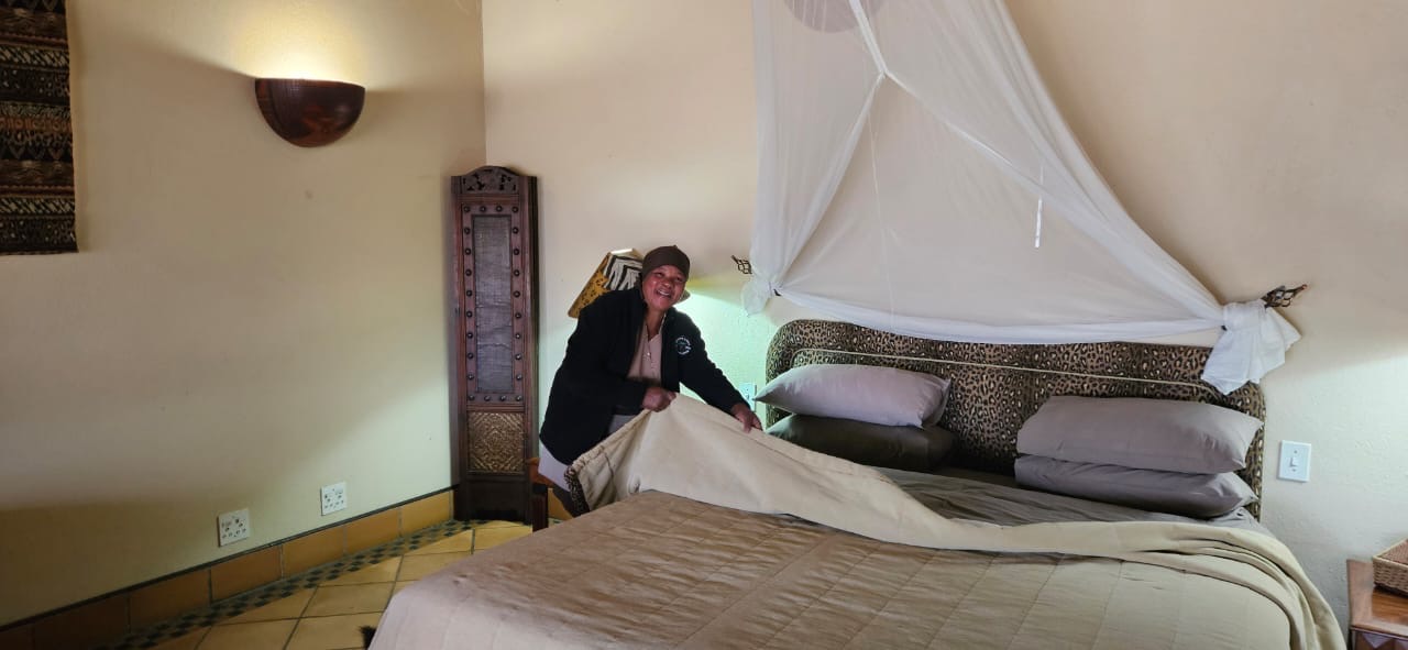 A Seringa housekeeping team member preparing a chalet bed